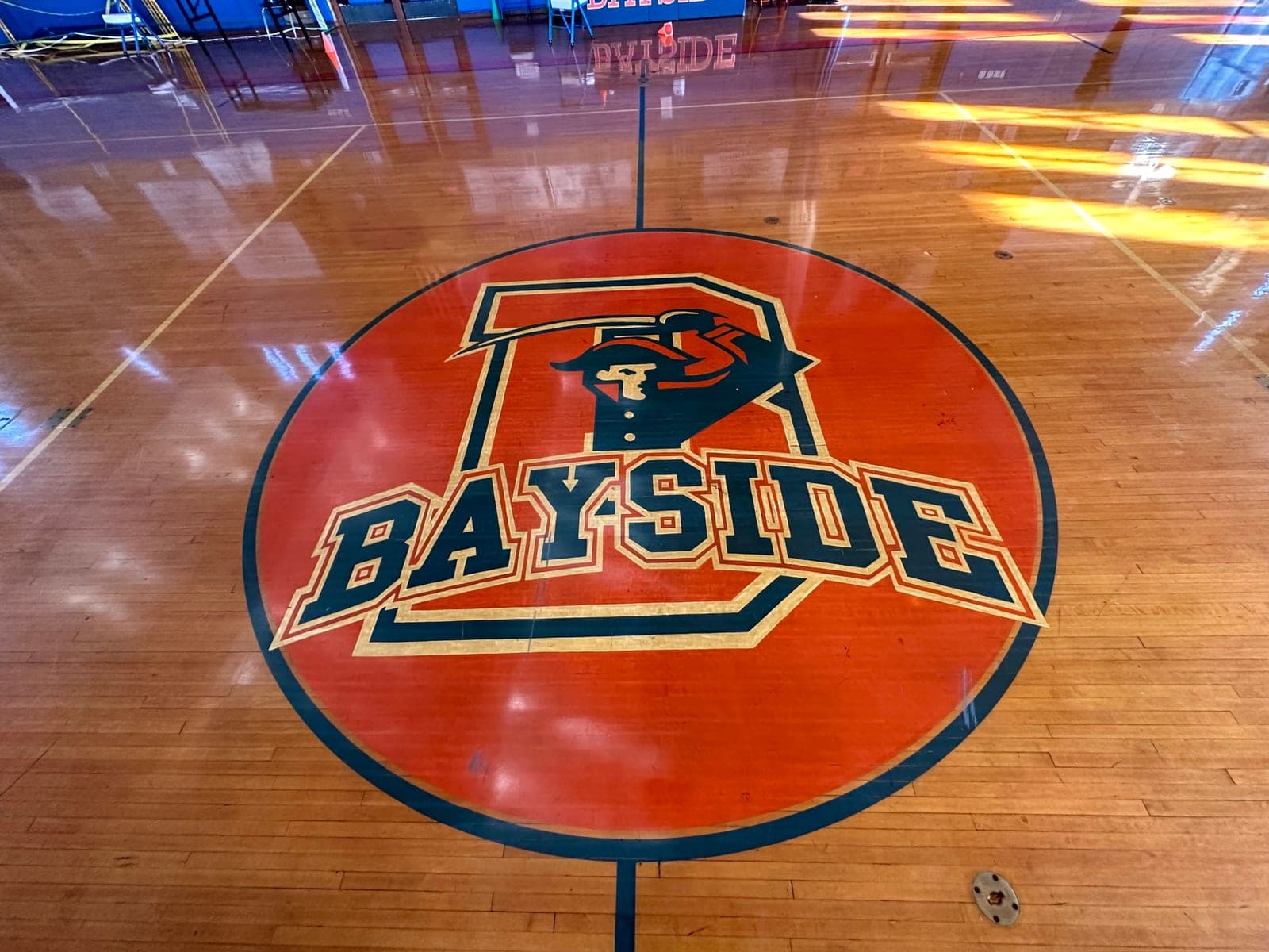 The painted center-court circle on a polished hardwood gym floor