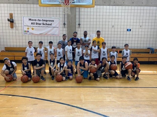 The whole session posed under the hoop, the front row kneeling with basketballs