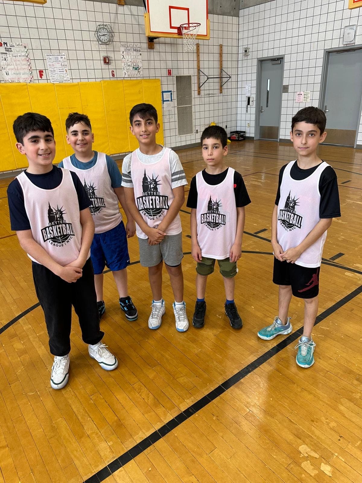 Five players in white BBLNYC pinnies standing in a row across the court